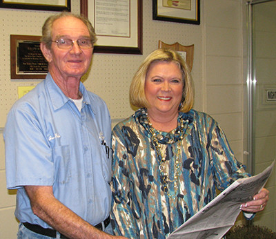 A&J Body Shop and Wrecker Service has sponsored the Kid Scoop page for several years. Jerry Fain, owner of the business, and Lu Shep Baldwin, The DPA's NIE coordinator, review some of the student activities found on the Kid Scoop page. The page is published weekly in the Wednesday edition of The DPA.