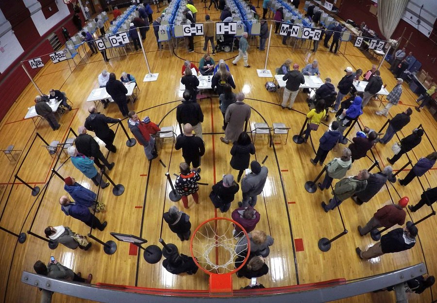 In this Nov. 2, 2018, file photo, voters wait in line in the gymnasium of Brunswick, Maine, Junior High School to receive ballots to vote in the mid-term election. New state data obtained by The Associated Press shows that tens of thousands more Maine Democrats headed to the polls in November than Republicans. (AP Photo/Robert F. Bukaty, File)