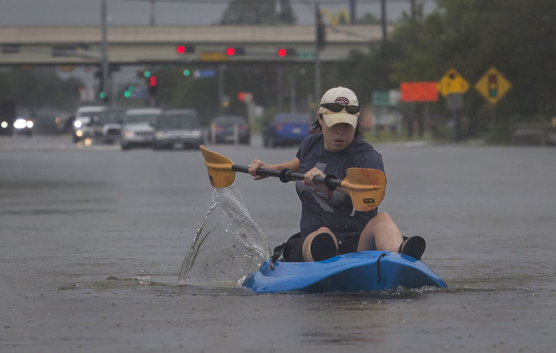 A woman kayaks down a flooded section of FM 518 near the intersection with Interstate 45 in League City on Sunday, Aug. 27. (Photo by Stuart Villanueva/Galveston County Daily News)